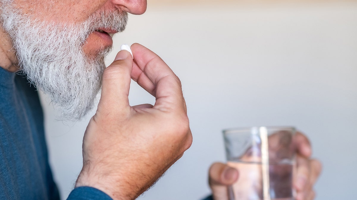 The man puts the pill in his mouth
